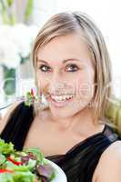 Smiling woman eating a salad