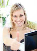 Delighted woman surfing the internet sitting on a sofa