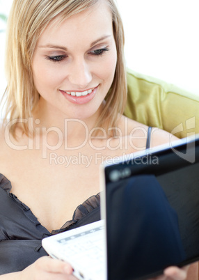 Bright woman surfing the internet sitting on a sofa