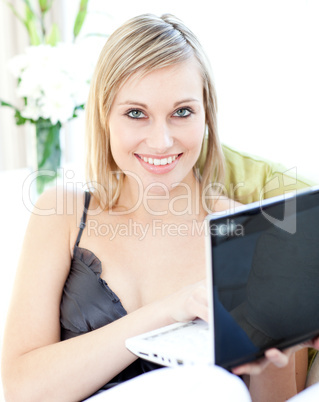 Smiling Caucasian woman surfing the internet at home