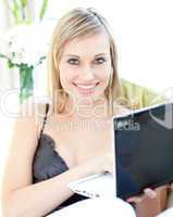 Smiling Caucasian woman surfing the internet at home