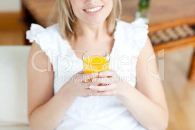 Smiling woman drinking an orange juice