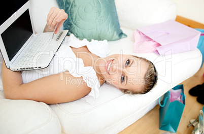 Smiling blond woman shopping on-line at home