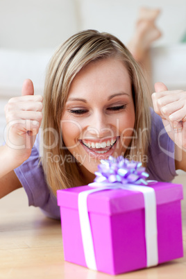 Joyful woman looking at a gift lying on the floor