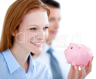 Smiling businesswoman holding a piggybank