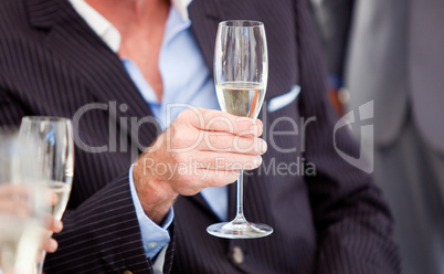 Close-up of a senior businessman holding a glass of Champagne