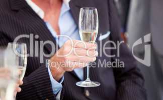 Close-up of a senior businessman holding a glass of Champagne