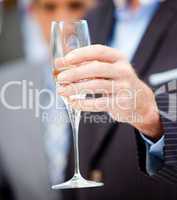 Close-up of a businessman holding a glass of Champagne