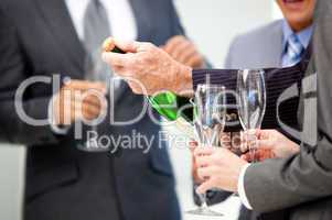 Close-up of a business man opening a bottle of Champagne