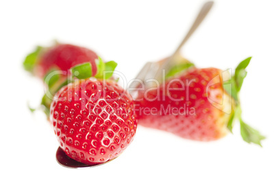 juicy strawberries on spoon isolated on white