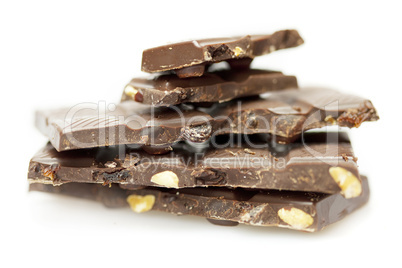 pieces of chocolate with nuts and raisins folded mountain, isolated on white