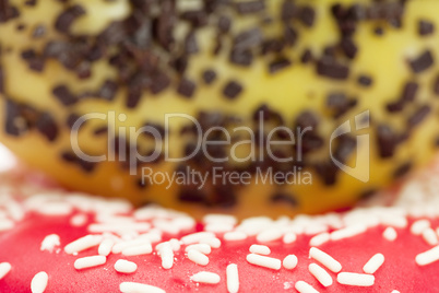 Donut with chocolate and colorful sprinkles, isolated on white