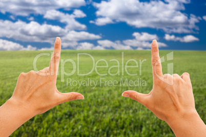 Female Hands Making a Frame Over Grass and Sky