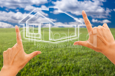 Female Hands Framing House Over Grass and Sky