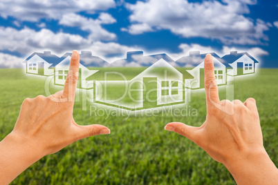 Female Hands Framing Houses Over Grass and Sky