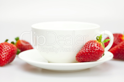 white cup and strawberries isolated on white