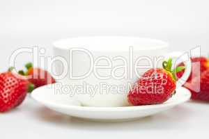 white cup and strawberries isolated on white