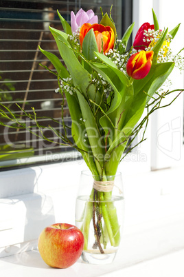 spring bouquet with tulips and an apple