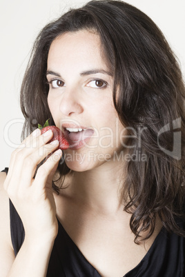 Frau isst eine rote Erdbeere