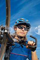 portrait of a young bicyclist in helmet with bicycle