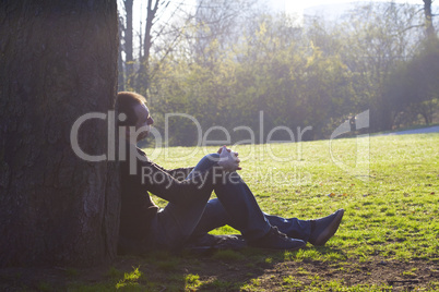 Man resting on the green grass in the sun