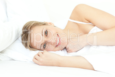 Jolly woman relaxing lying on a bed