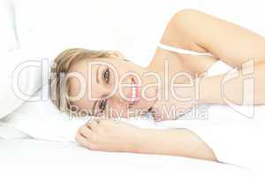 Jolly woman relaxing lying on a bed