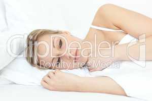 Bright woman relaxing in a bed