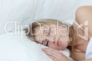 Blond woman sleeping in a bed