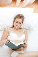 Attractive woman in underwear reading a book