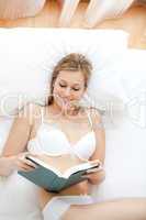 Smiling woman in underwear reading a book