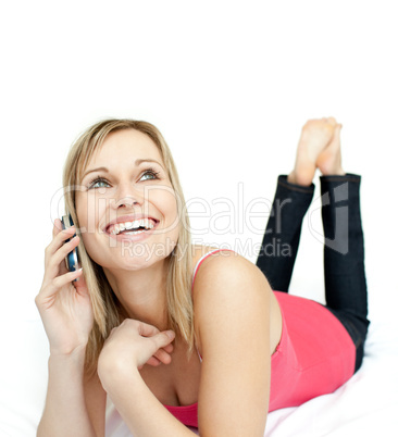 Jolly woman talking on phone lying on a bed