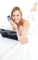 Happy woman with a thumb up shopping on-line