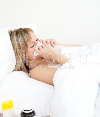 Sick woman blowing lying on a bed