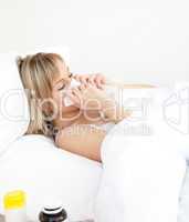 Sick woman blowing lying on a bed