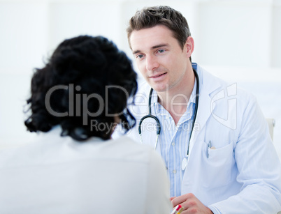 Handsome doctor talking with his patient for the annual check-up