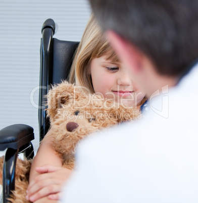 Male doctor talking with a disabled little girl