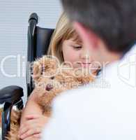 Male doctor talking with a disabled little girl