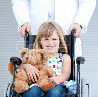 Portrait of a little girl sitting on the wheelchair supported by