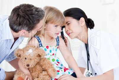 Radiant female doctor examining little girl with medical equipme