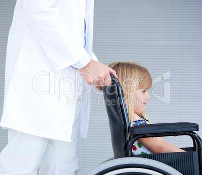 Smiling little girl sitting on the wheelchair supported by a doc