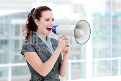 Self-assured businesswoman yelling through a megaphone