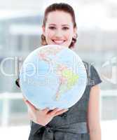 Assertive businesswoman holding a terrestrial globe
