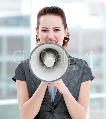 Furious businesswoman yelling through a megaphone