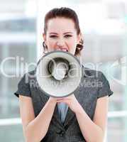 Furious businesswoman yelling through a megaphone