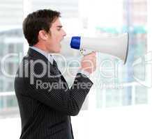 Frustrated businessman yelling through a megaphone