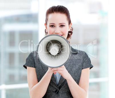Confident businesswoman yelling through a megaphone