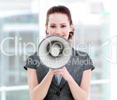 Confident businesswoman yelling through a megaphone