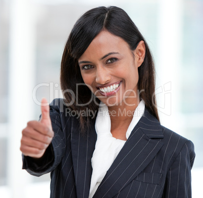 Cheerful businesswoman with a thumb up standing