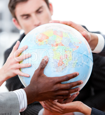 Close-up of a business team holding a terrestrial globe